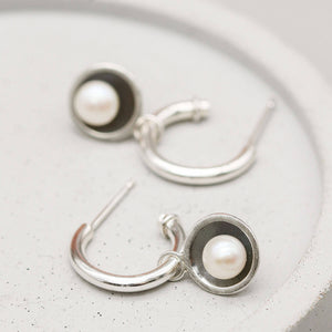 Contemporary hoop earrings with pearl drop crafted from sterling silver with oxidised pearl charm settings.