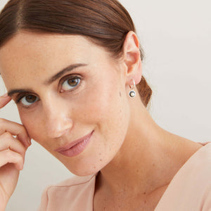 Handmade hoop earrings with pearl drop worn to demonstrate their contemporary Art Deco-inspired design. 