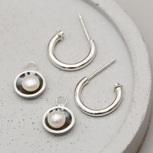 Black pearl hoop earrings featuring removable pearl charms and solid sterling silver hoops.