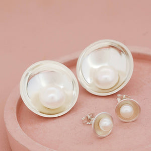 Sterling silver pearl stud earrings shown alongside the larger size option, displaying size comparison for customers.