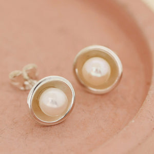 Real pearl stud earrings on a pink dish — classic Pearl Earrings for women and elegant real pearl stud earrings handmade in silver.