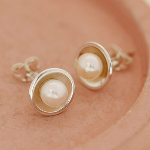 Minimal real pearl stud earrings on a pink ceramic dish, versatile Pearl Earrings for women made to wear every day.