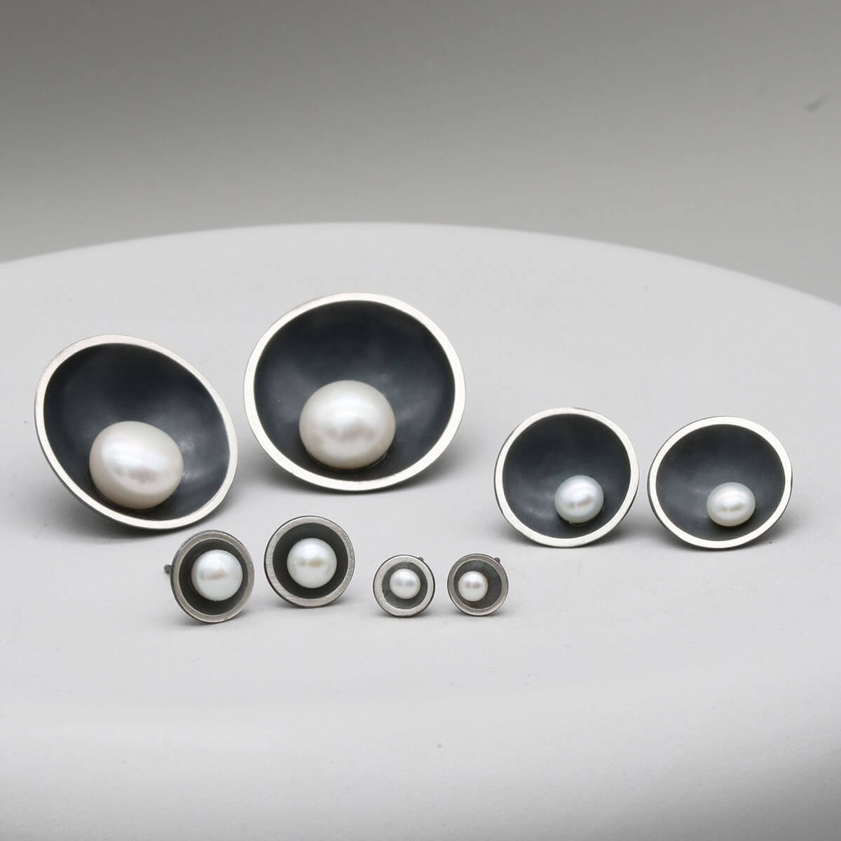 Comparison of Petite, Classic, Signature and Statement pearl stud earrings showing all four sizes side by side.