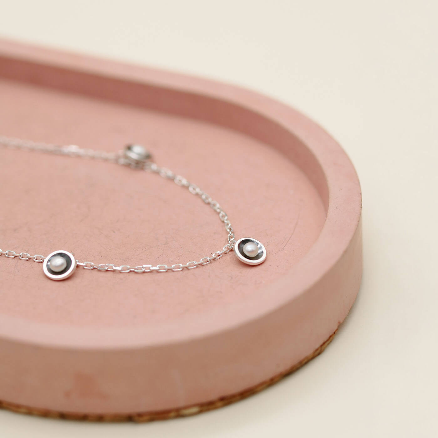 Delicate layering pearl necklace featuring five mini freshwater pearl stations on an adjustable oxidised sterling silver curb chain.