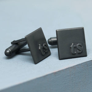 TS initial cufflinks in matte black sterling silver, personalised gift for a son, groom or husband on a deep blue background