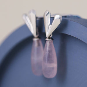 Pink heart earrings with wax-carved faceted heart and soft pink rose quartz, heart dangle earrings shown on a blue dish background