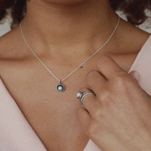Model wearing a handcrafted black pearl pendant necklace in oxidised sterling silver with a genuine freshwater pearl on an 18-inch chain.