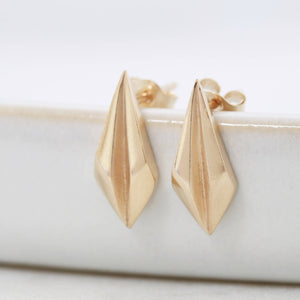 Side view of gold art deco earrings on pale grey background, minimalist geometric wedding jewellery.