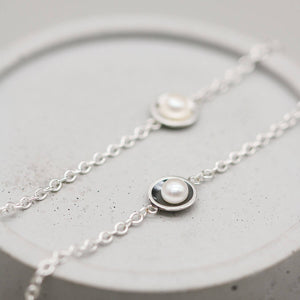 Matching black and silver pearl bracelets featuring genuine freshwater pearls and handcrafted sterling silver settings.