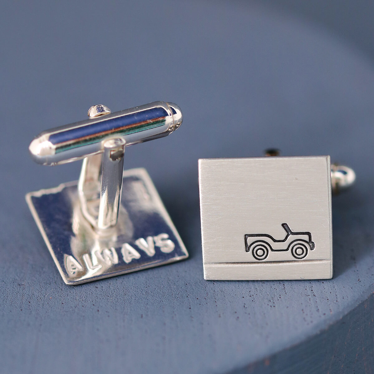 Close-up of sterling silver Car cufflinks with hand-stamped car design, photographed on a deep blue background – perfect gift for car lovers.