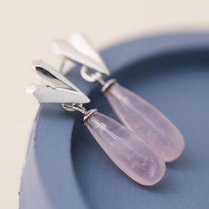 Pink heart earrings showing faceted silver heart detail and rose quartz drop, heart dangle earrings displayed on a blue dish