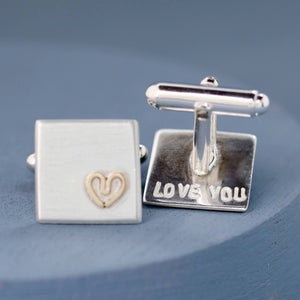One cufflink face on, the other upturned to show a hand-stamped secret message on the reverse — Custom cufflinks for groom.