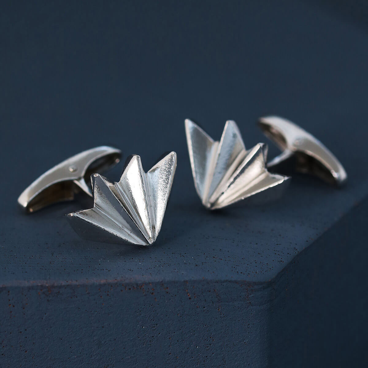 Close-up showing art deco cufflink design on deep blue background, luxury men’s silver cufflinks perfect for anniversary or milestone gift