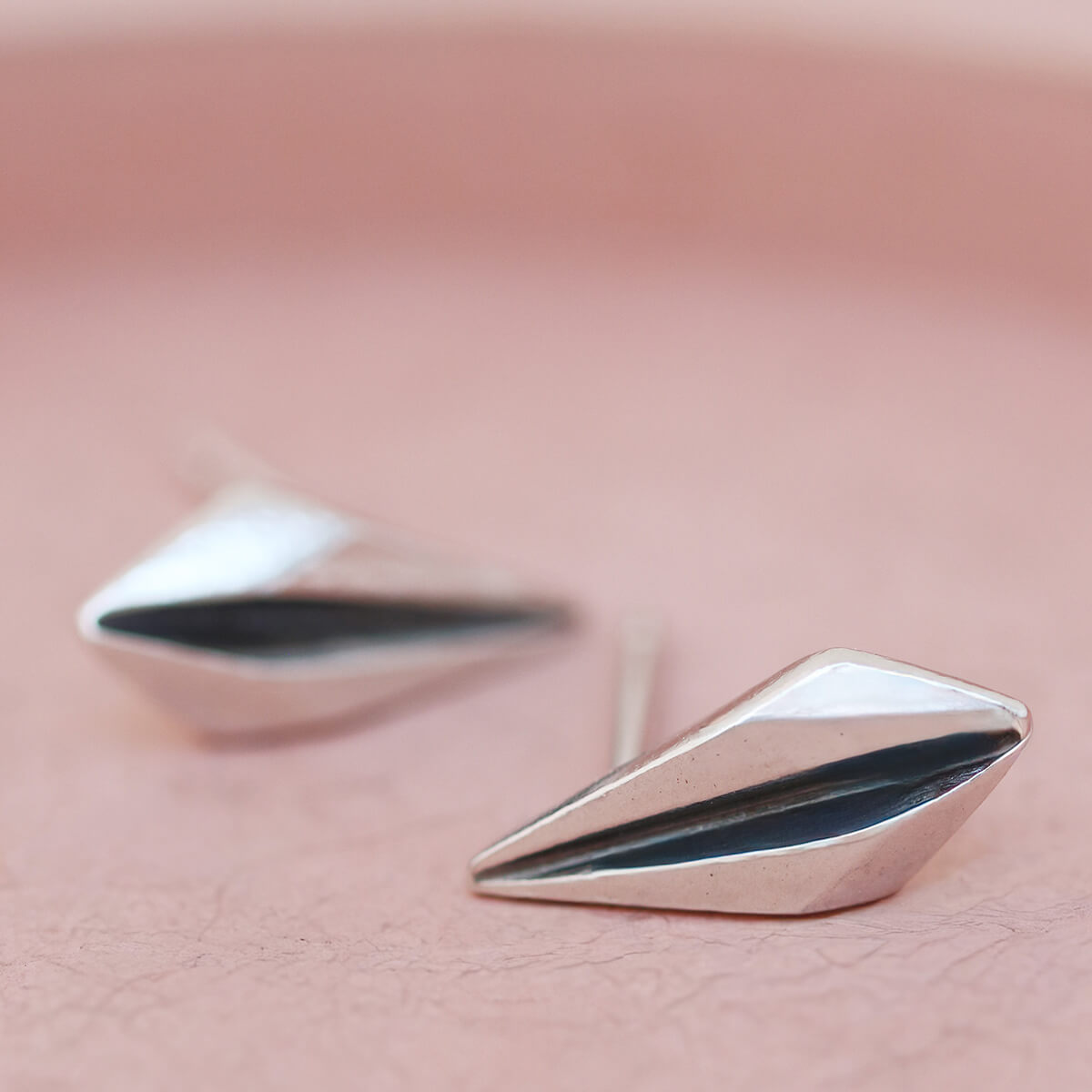 Art deco earrings studs photographed on pink dish for anniversary or birthday gifting.