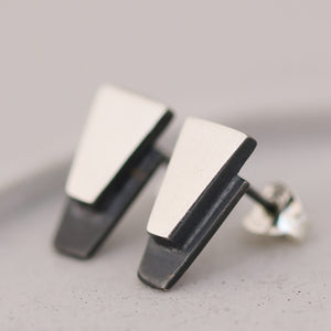 Geometric black stud earrings for women resting on grey dish, stylish sterling silver jewellery for milestone birthday gifts.