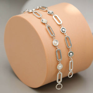Close up of a handmade sterling silver pearl chain bracelet highlighting polished pearl settings and genuine freshwater pearls.