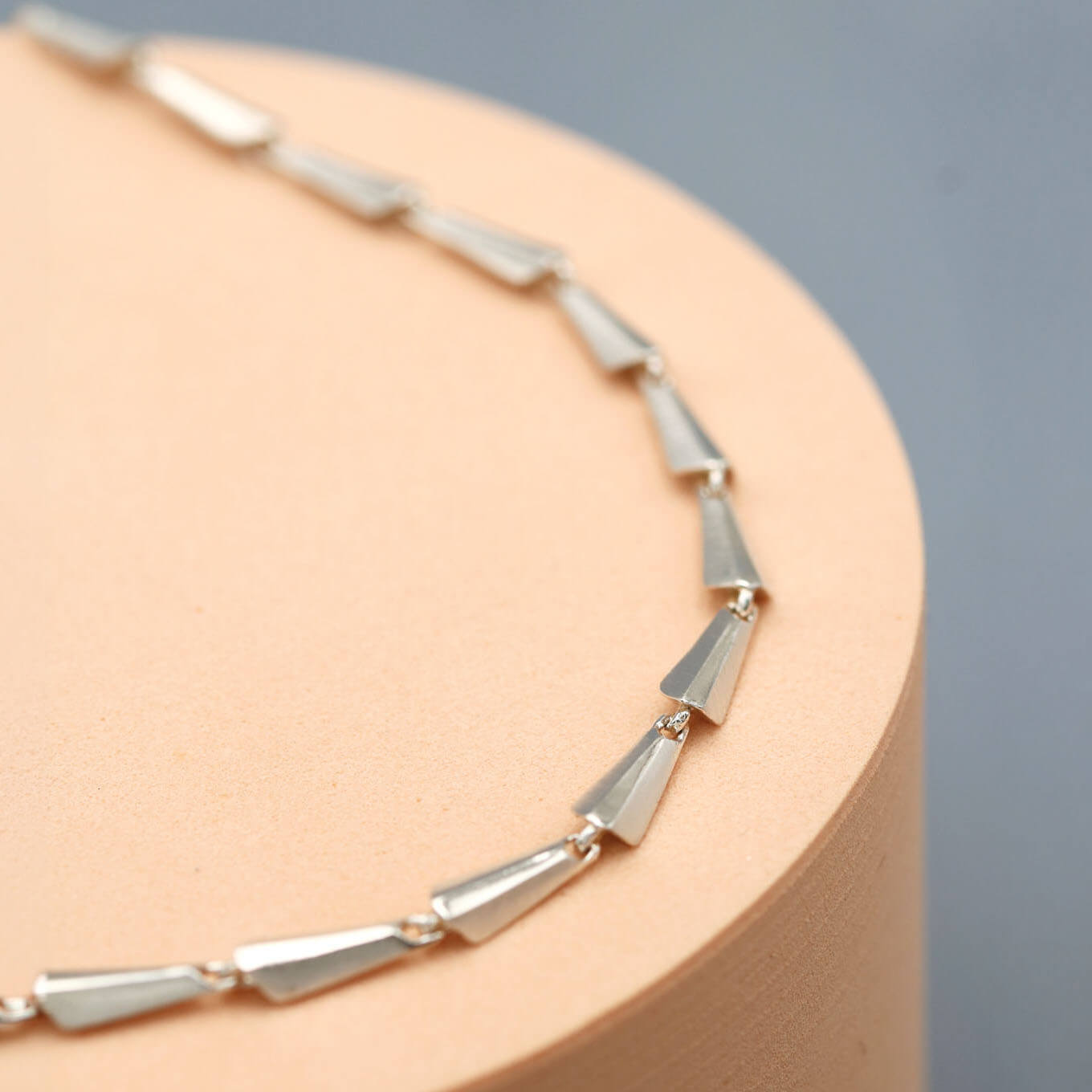 Handmade sterling silver link necklace with connected sculptural links, photographed as a modern statement necklace