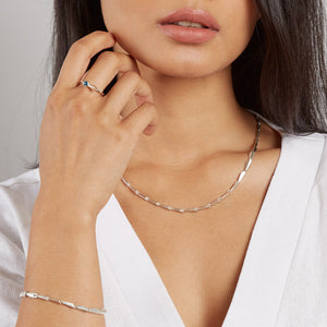 Model wearing a silver chain link necklace with sculptural geometric links, a modern necklace for everyday and occasion wear