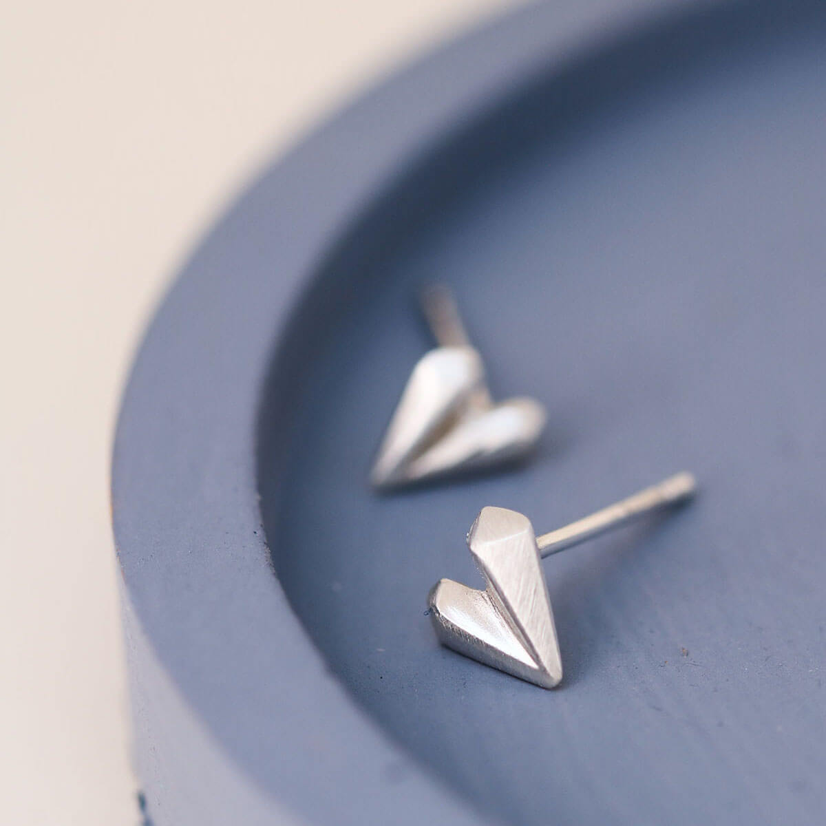 Love heart earrings photographed on blue dish, minimalist silver heart stud earrings for anniversary gift