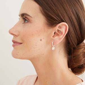 Sterling silver pearl drop hoop earrings worn to demonstrate their versatile two-in-one design. 