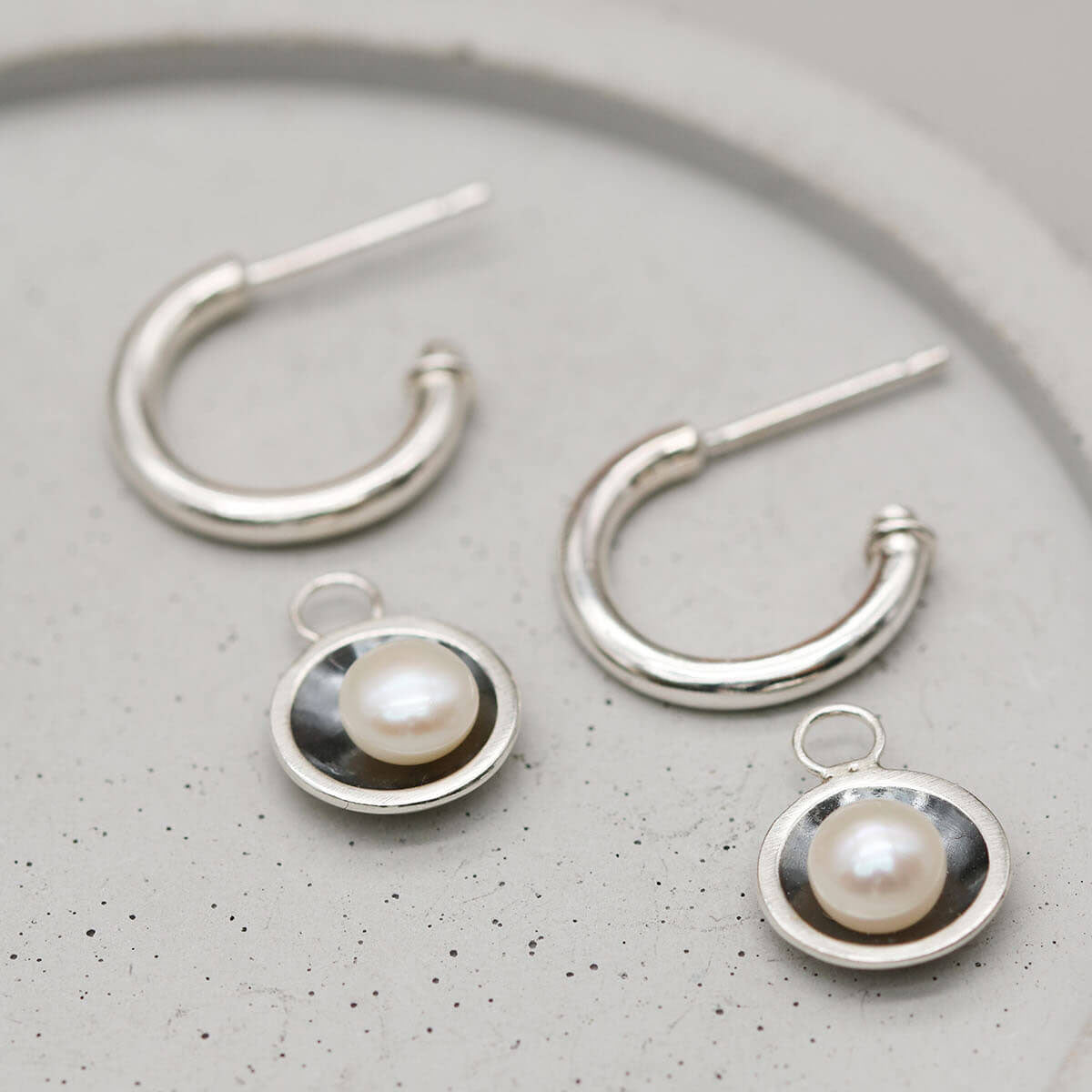 Oxidised sterling silver black pearl hoop earrings with genuine freshwater pearl charms for versatile everyday wear.