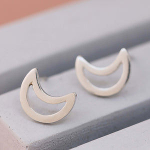 Polished silver moon earrings on grey dish, classic moon stud earrings