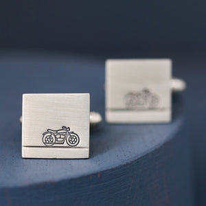Close-up of sterling silver motorbike cufflinks on deep blue background, perfect wedding cufflinks for a motorbike lover