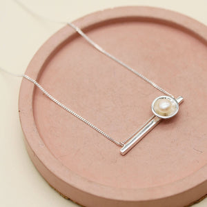 Sterling silver necklace with pearl pendant featuring a polished horizontal bar, freshwater pearl and delicate diamond-cut chain.