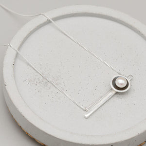 Contemporary black geometric pearl necklace with an Art Deco inspired horizontal bar pendant and freshwater pearl.