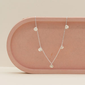 Sterling silver pearl chain necklace displayed on a pink ceramic dish, showing the adjustable 16 to 18 inch chain and delicate freshwater pearl stations.