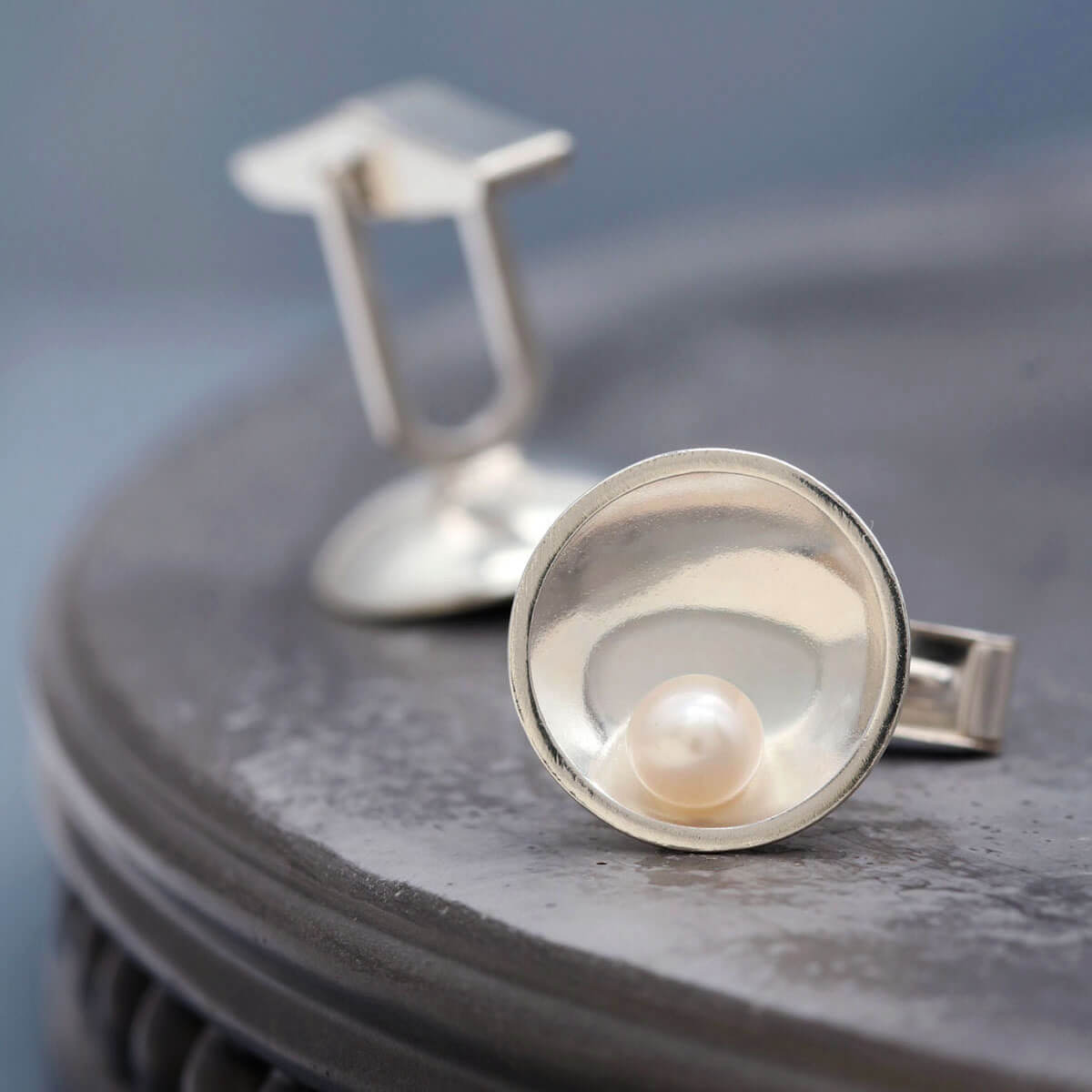 Sterling silver pearl cufflinks featuring freshwater pearls and an Art Deco inspired geometric design.