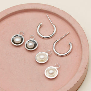 Sterling silver hoop earrings with pearls shown alongside the oxidised black pearl charm version for comparison.
