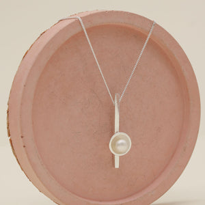 Close up of a pearl wedding necklace handcrafted in solid sterling silver with a genuine freshwater pearl.