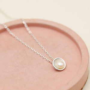 Minimalist silver pearl pendant necklace showcasing a round freshwater pearl in a handcrafted sterling silver design.