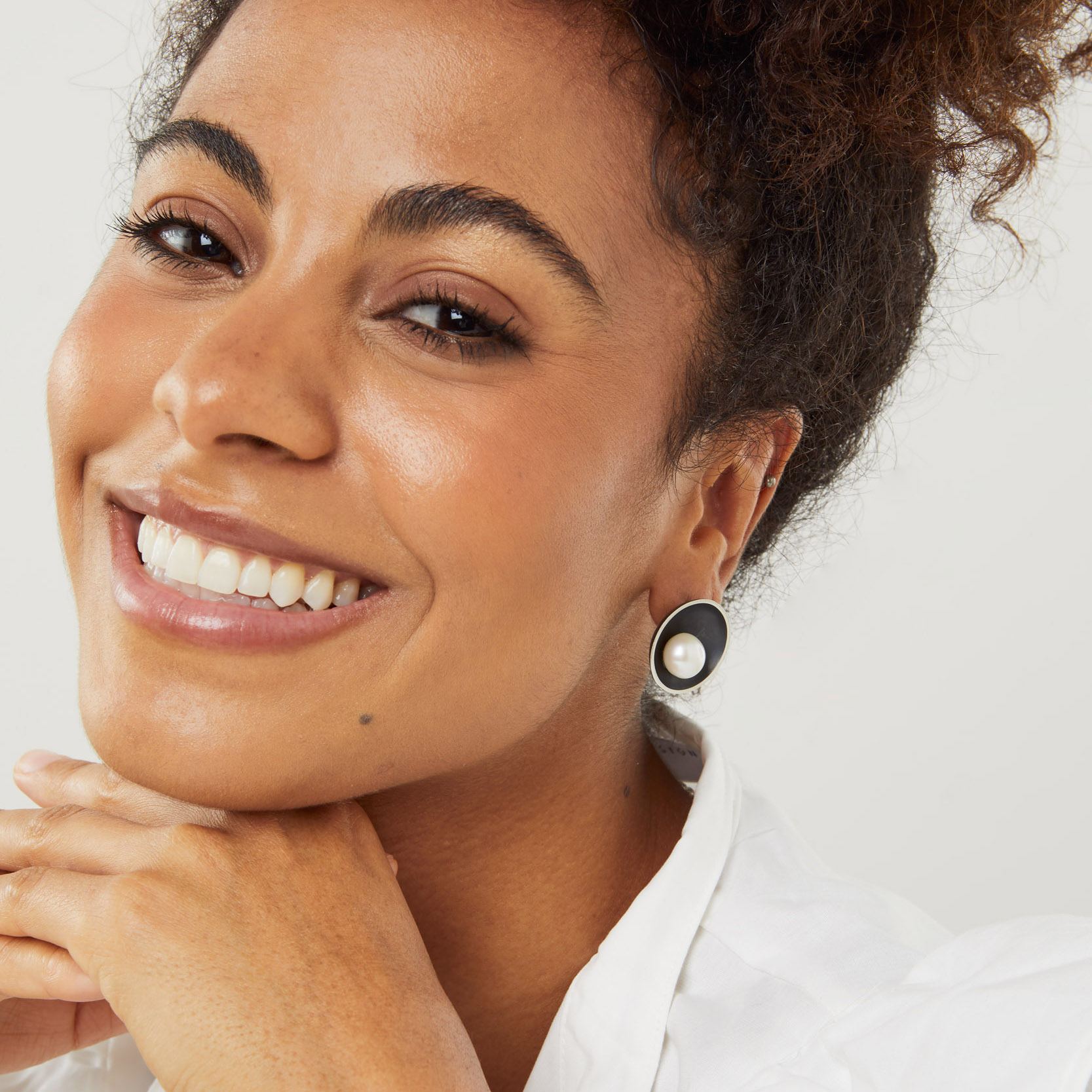 Contemporary oxidised silver pearl earrings worn by model