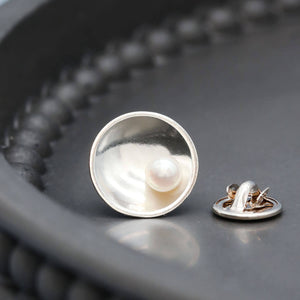 Handmade sterling silver pearl tie pin with a genuine freshwater pearl displayed on a dark grey dish.