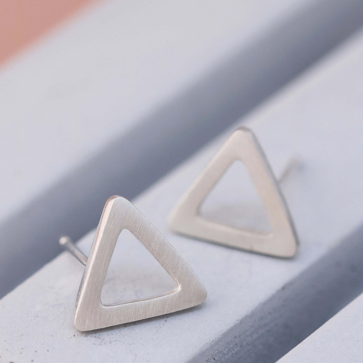 Matte Silver Triangle Earrings on grey dish, minimalist triangular earrings