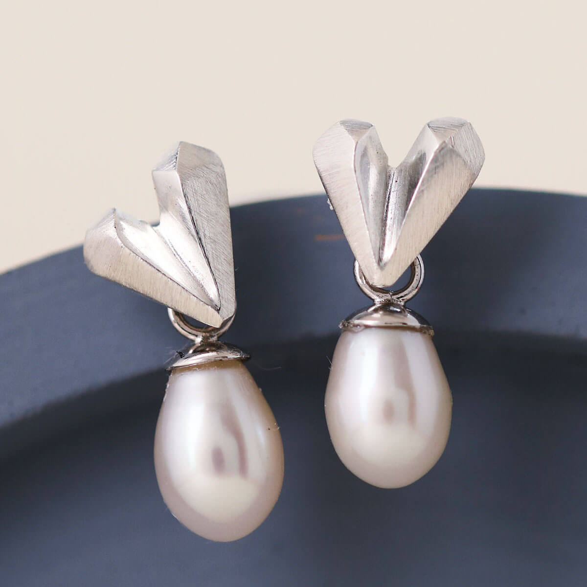 Handmade heart pearl earrings on a blue dish, sterling silver heart stud with dangling pearl, perfect silver wedding earrings for brides