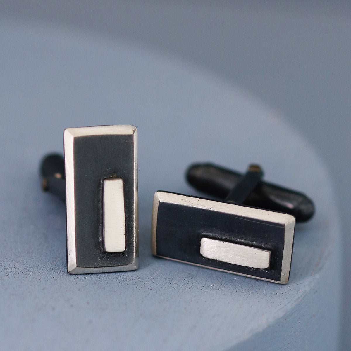 One cufflink face front on and the other angled to show depth and shine, beautifully presented on a deep blue background — ideal special gift for husband’s birthday.
