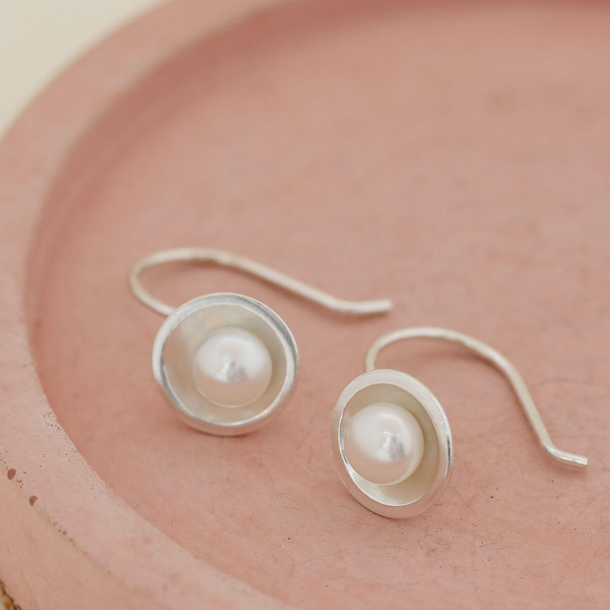 Minimalist sterling silver pearl drop earrings with genuine freshwater pearls and fixed hook ear wires.