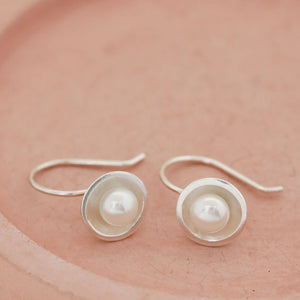 Handmade sterling silver drop freshwater pearl earrings showcasing polished silver and naturally lustrous freshwater pearls.