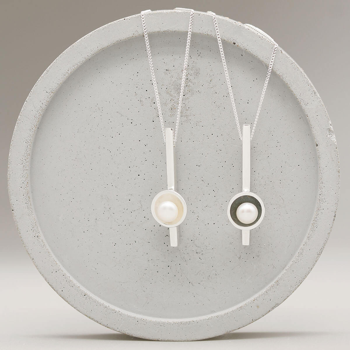 Black pearl bar necklace shown alongside the sterling silver version, comparing the oxidised and polished finishes.