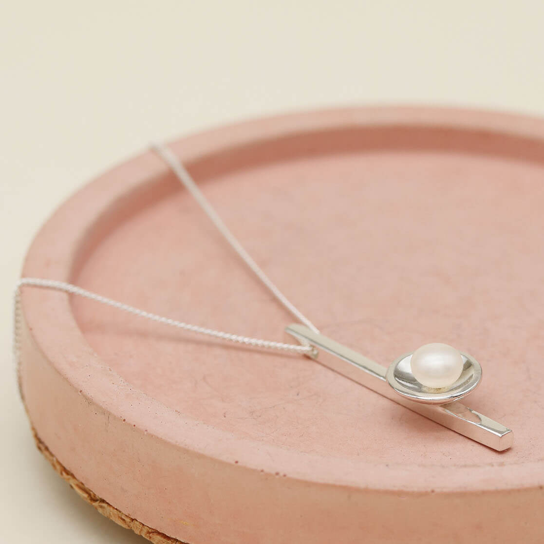 Simple sterling silver pearl necklace featuring an elongated bar pendant and polished silver finish.