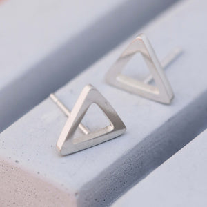 Polished Silver Triangle Earrings on grey dish, modern triangular earrings