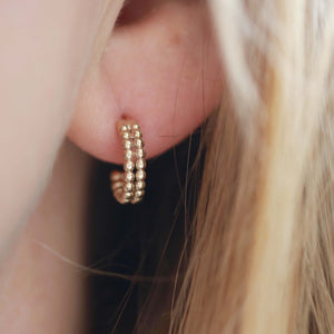 Model wearing small 9ct gold hoop earrings, showing the double-hoop beaded design as subtle everyday 9 carat gold hoops.