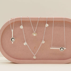 Sterling silver pearl chain necklace displayed alongside the original pearl pendant necklace, long pearl bar necklace and horizontal geometric pearl necklace, highlighting the different handcrafted pearl necklace designs.