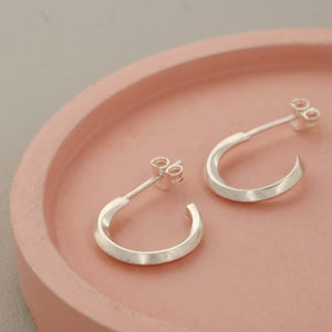 Silver hoop stud earrings on a pink dish, modern sterling silver hoop earrings for women perfect for everyday wear