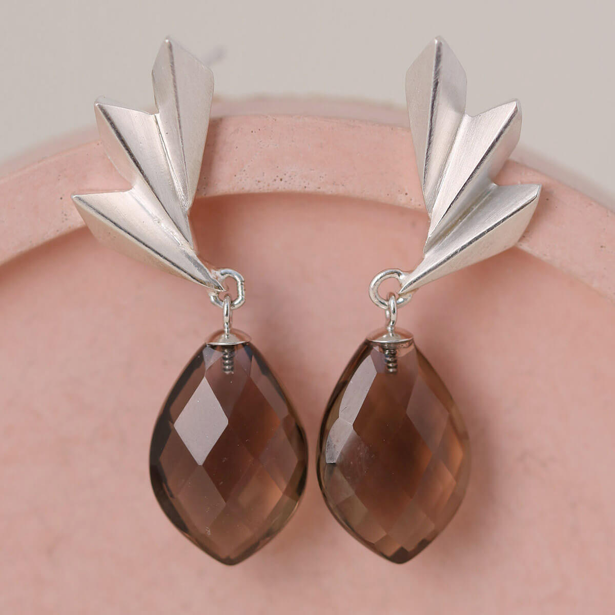 Detailed pink dish shot of smoky quartz earrings highlighting the architectural fan shape; stylish art deco statement earrings suited to festive gifting.