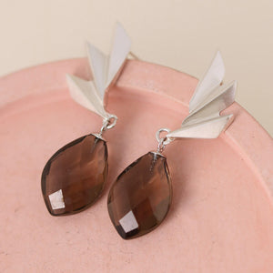 Smoky quartz earrings photographed on a pink background showing the textured fan shape; handmade art deco statement earrings for jewellery lovers.