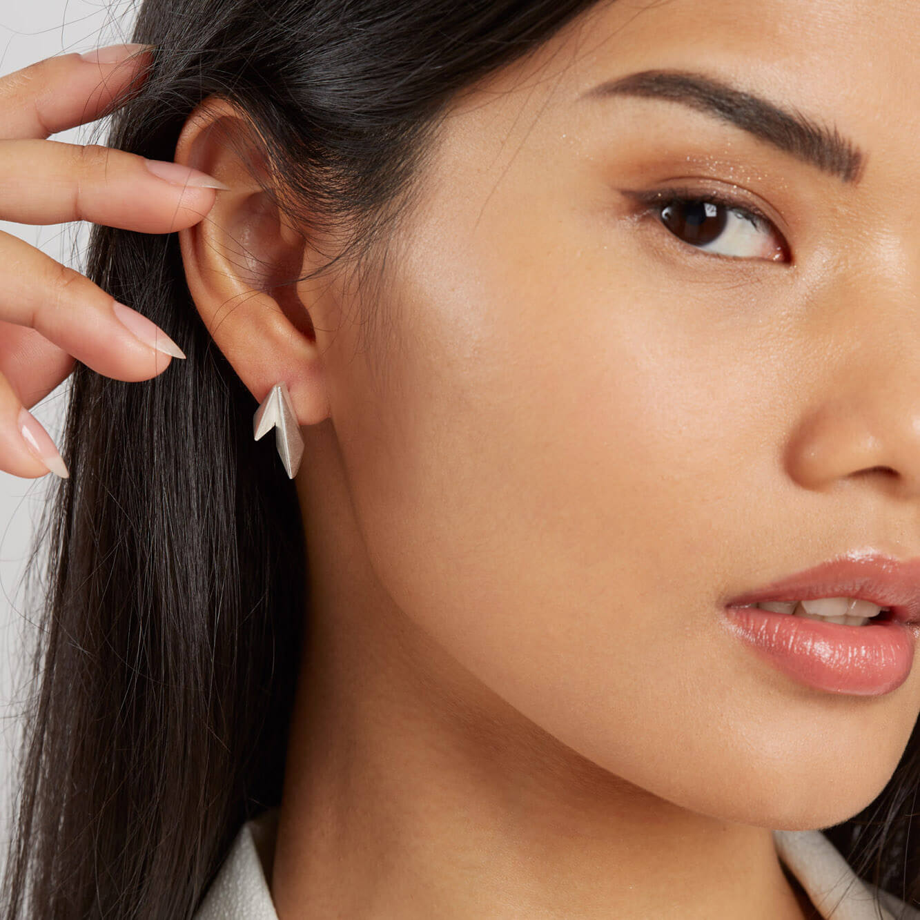 Art Deco silver stud earrings modelled on a woman, elegant geometric jewellery for everyday wear or a special occasion
